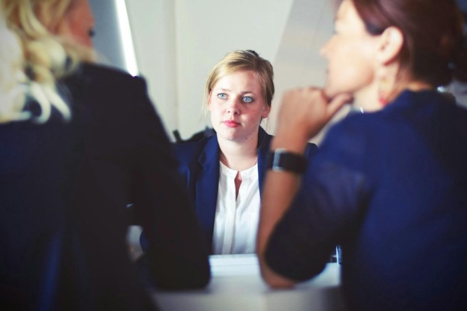 Three individuals in a serious discussion, with one woman attentively listening—illustrating the importance of seeking advice after a short term disability claim denial.
